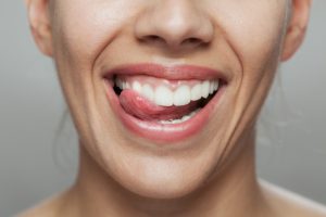 close up of woman with tongue poking between her teeth