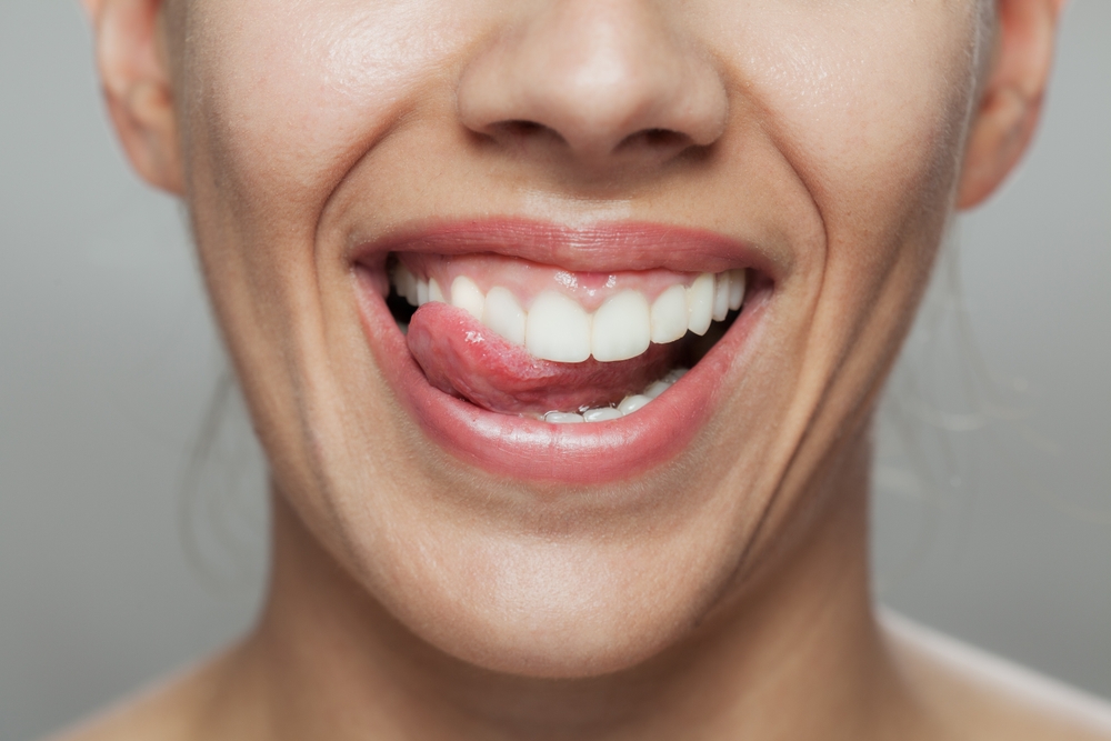 close up of woman with tongue poking between her teeth